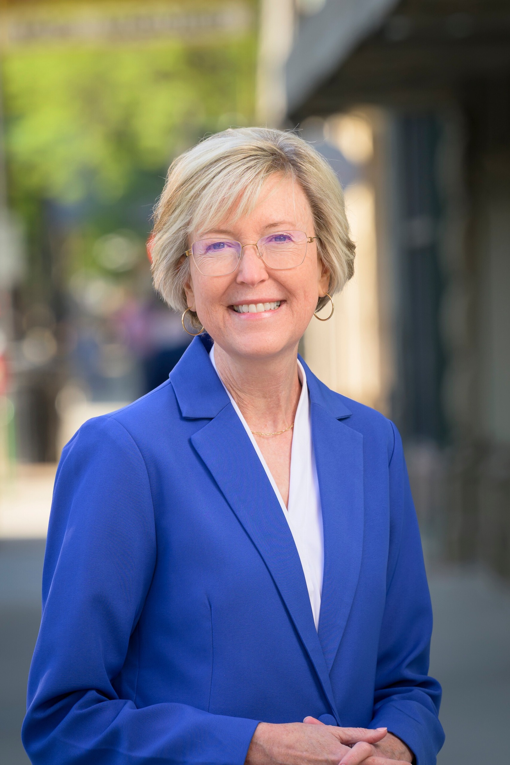 Headshot of Elizabeth Lewis in front of City logos