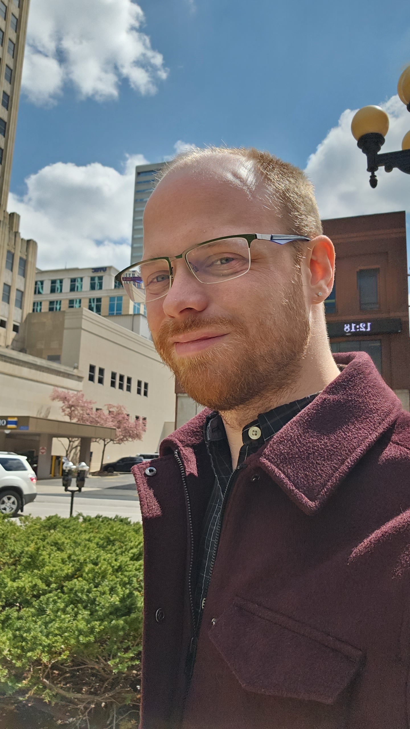 Headshot of Nathan in front of City Logos