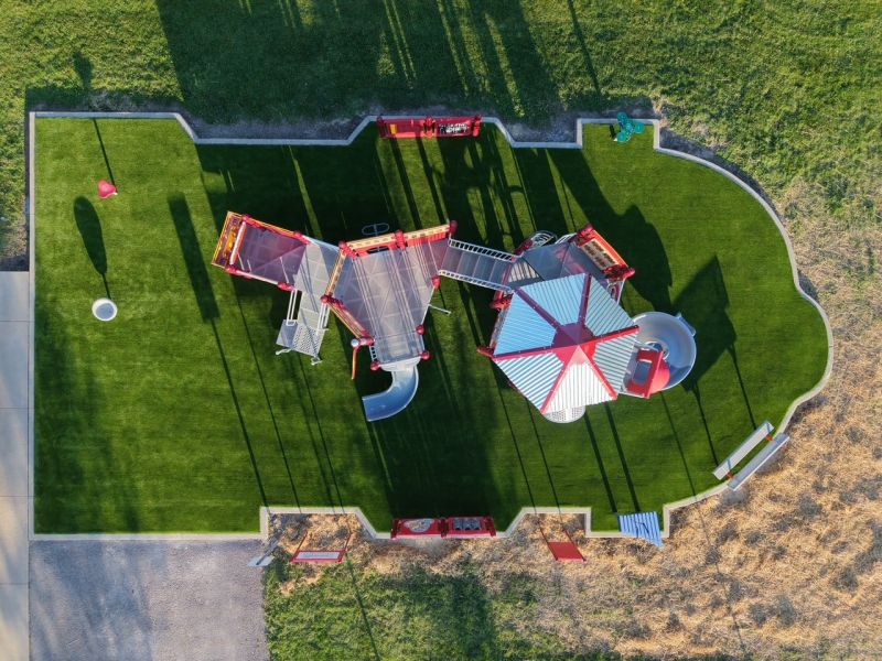 Image of completed playground, featuring a bright red firetruck and other fire-themed equipment