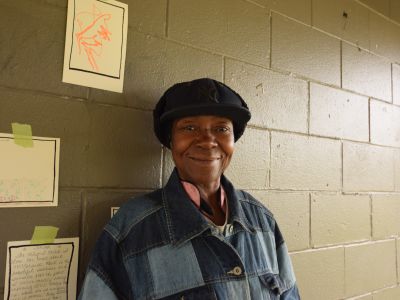 Image of a resident standing in front of a wall at the Shout Out Fort Wayne event in the Harvester Neighborhood