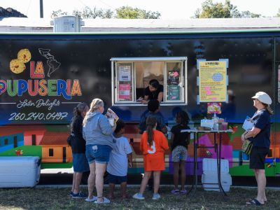 Community members enjoy the food truck, La Pupuseria