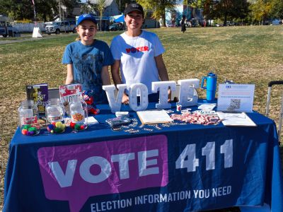 Vote 411 volunteers standing at a table for the Packard Park celebration event